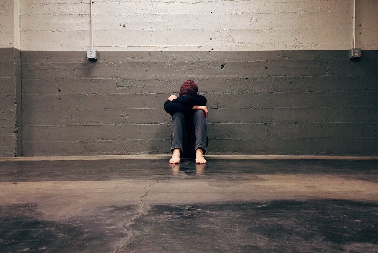 Person Leaning on Wall, seemingly depressed.